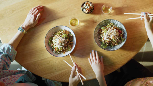 People using chopsticks while eating.